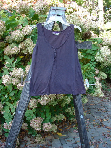 Barclay Batiste Decora Tiny Tank Unpainted Deep Burgundy Size 1 displayed on a wooden ladder, featuring a front vertical neckline tie and diagonal insert, perfect for mixing and matching with other Barclay pieces.