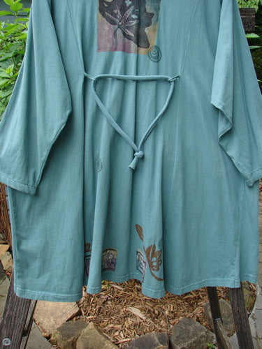 1994 Falling Leaves Jacket Asian Leaves Deep Sea Altered OSFA displayed on a clothes rack, showcasing unique stitching, gathered pointed collar, wider neckline, original buttons, A-line shape, and cord-accented rear loops.
