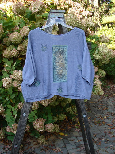 1995 Cotton Rayon Short Sleeved Cardigan Sweater Friendly Garden Dusk Mélange Size 3 displayed on a wooden swing, featuring colorful buttons, varied textures, and garden critter theme paint.