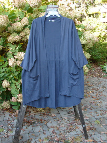 Barclay Bamboo Dolman Day Jacket with vintage floral rear detail and open front pockets displayed on a rack.