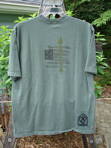 2000 Short Sleeved Tee Celtic Letter Park Size 1 displayed on a swinger, featuring a slightly thicker ribbed neckline, drop shoulders, and a longer straight shape with a classic Celtic letter theme.