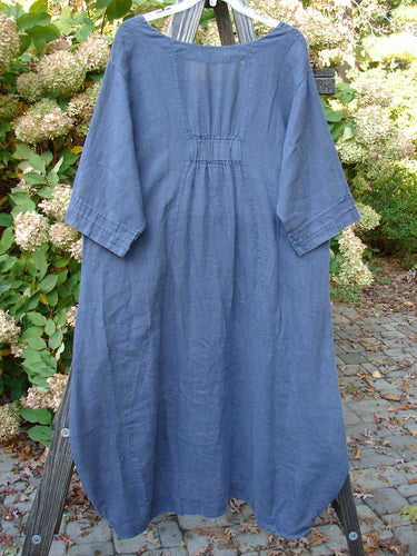 Barclay Linen Rear Tab Pocket Dress Dusk Florals Dusty Navy Size 1 displayed on a swing, showcasing its scooped neckline, pleated sleeves, and varying hemline.