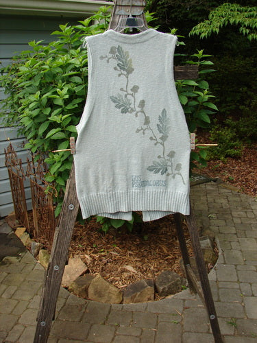 1998 Botanicals Sprig Vest River Altered Size 1, featuring oversized stoneware buttons, deep V neckline, and varying knit textures, displayed on a wooden ladder.