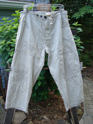Magnolia Pearl NWT European Denim Lilou Trouser Natural Pinstripe OSFA hanging on a clothesline, showcasing wide straight legs, contrasting patches, and dual side pockets, emphasizing its artistic and vintage-inspired design.