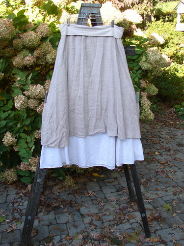 Barclay Linen Fold Over Two Tier Skirt Translucent Daisy Mallow Size 1 displayed on a stand, showcasing its full paneled waistline, dual A-line hemline, and daisy-themed lower border.