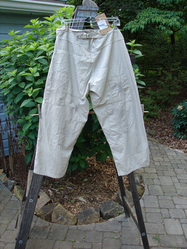 Magnolia Pearl NWT European Denim Lilou Trouser Natural Pinstripe OSFA hanging on a clothesline, showcasing its wider straight leg shape and contrasting overlay patches.