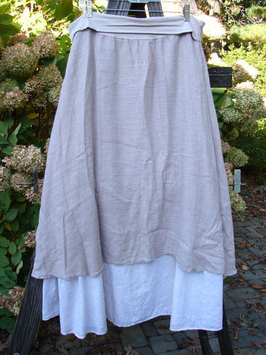 Barclay Linen Fold Over Two Tier Skirt Translucent Daisy Mallow Size 1 displayed outdoors, featuring a full paneled waistline, dual A-lined hemline with fluttery upper layer, and daisy-painted lower border.