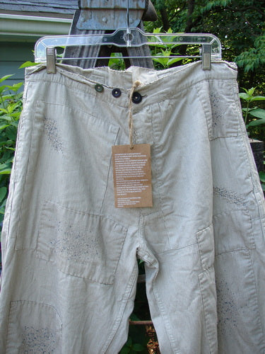 Magnolia Pearl NWT European Denim Lilou Trouser Natural Pinstripe OSFA hangs on a clothesline, showcasing its wide straight leg, contrasting overlay patches, and signature Pearl interior rear waist patch.
