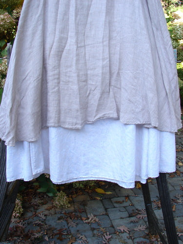 Barclay Linen Fold Over Two Tier Skirt on a rack, featuring a paneled waistline and fluttery upper layer with daisy-themed lower border.