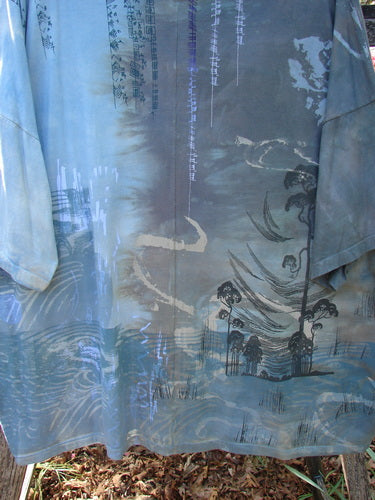 Barclay Center Seam Wide Line Tee Windy Bonsai Mottled Day Storm OSFA: A loose, hand-dyed blue-gray tunic featuring abstract landscapes and calligraphic motifs, hanging outdoors, showcasing its seamless, generous design.