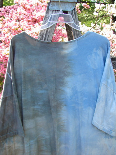 Barclay Center Seam Wide Line Tee Windy Bonsai Mottled Day Storm OSFA on a wooden trellis, highlights a tie-dye effect with rounded neckline, drop shoulders, and a boxy shape, amidst blooming bushes.