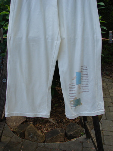 2001 Cotton Lycra Matchstick Pant Junk Drawer Fizz Size 2 featuring unique drawings, a thin waistband, wide bottoms, and no pockets for a slimming look, showcased outdoors.