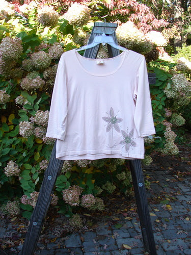 Barclay Cotton Lycra Three Quarter Sleeved A Line Tee Double Daisy Pink Tile Size 1 displayed on a wooden stand, showcasing its floral design and three-quarter sleeves.