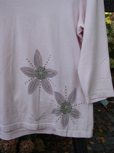 Barclay Cotton Lycra Three Quarter Sleeved A Line Tee Double Daisy Pink Tile Size 1 features a white shirt adorned with purple flower designs, highlighting its A-line shape and three-quarter length sleeves.