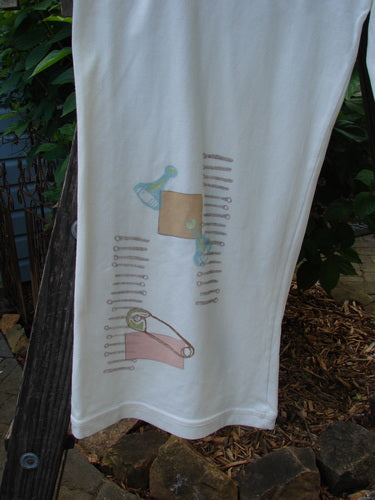 2001 Cotton Lycra Matchstick Pant Junk Drawer Fizz Size 2, featuring a thin waistband, wide bottoms, and unique junk drawer-themed paint with no pockets for a slimming look.