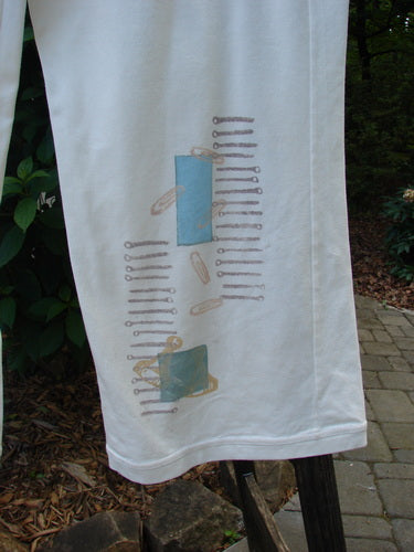 2001 Cotton Lycra Matchstick Pant Junk Drawer Fizz Size 2, featuring a thin waistband and wide bottoms, displayed on a white towel with blue and brown designs.