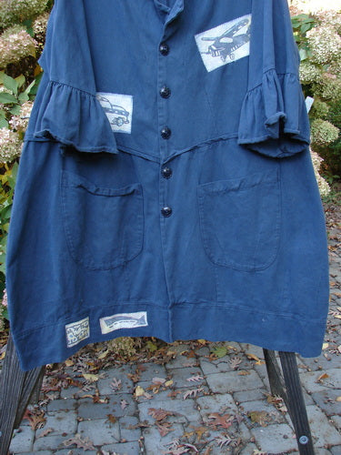 Barclay PMU Patched Twill Decora Brushed Flutter Coat Travel Navy Size 1 displayed on a rack, featuring 3/4 flutter sleeves, large round pockets, and a swingy hemline with patches.