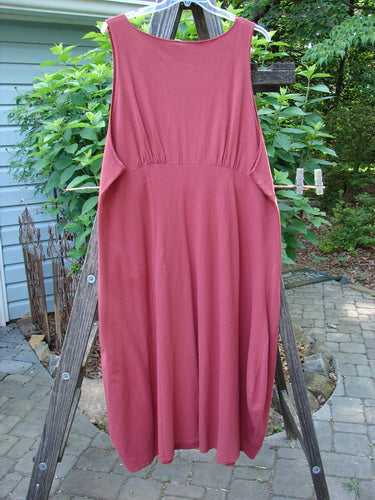 1993 Crepe Teapot Jumper Unpainted Cranberry Size 1 displayed on a clothes rack, featuring a unique A-line flair with double pleated vertical front accents and a rounded neckline.