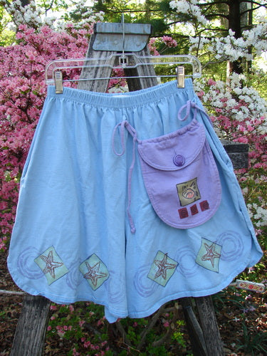 1997 Collector's Short Starfish Atlantis Size 1, featuring hand-painted starfish appliqués and faint swirls, hangs on a ladder. Includes a removable lavender pocket purse, highlighting vintage Blue Fish individuality.