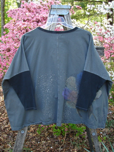 Barclay Cotton Lycra Rib Colors Contrast Sweatshirt Peony Night Grey OSFA, featuring a relaxed fit with charcoal sleeves, paint-splatter design, and ribbed accents, displayed on a hanger outdoors against blooming shrubs.