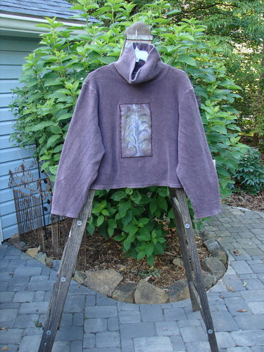 2000 PMU Celtic Moss Big Collar Top Aubergine Size 2 displayed on a wooden stand, showcasing its unique plush dense fleecy fabric and distinctive front leaf patch.