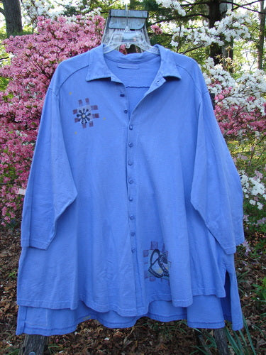 1997 Work Jacket Water Can Skylark OSFA draped on a hanger, showcasing long sleeves, button-front, embroidered accents, and deep side pockets, set against a backdrop of flowering shrubs, embodying timeless vintage style.