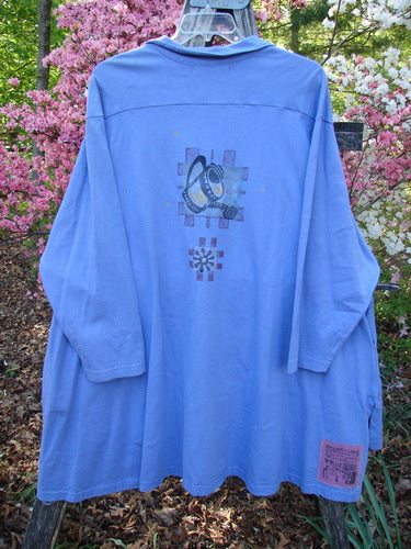 1997 Work Jacket Water Can Skylark OSFA, loose-fitting with long sleeves and abstract back graphic, displayed on a hanger outdoors among blooming shrubs, revealing a front label patch.