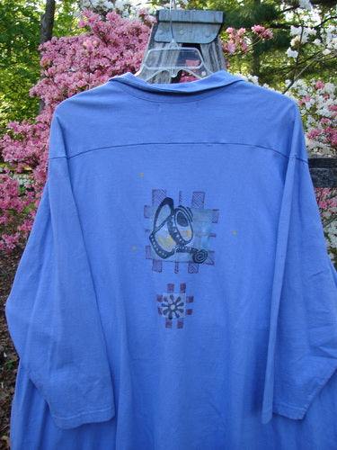 1997 Work Jacket Water Can Skylark OSFA, a loose-fitting light blue long-sleeve shirt with abstract graphics on the back, hangs outdoors. It features textured buttons, deep pockets, and a unique hemline.