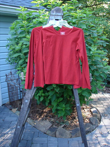 2000 Cotton Lycra Long Sleeved Layering Tops Unpainted Bittersweet Size 1, displayed on a hanger, showcasing its fitted and shapely design with a rounded feminine neckline and superior stretch fabric.