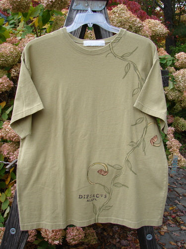 1998 Botanicals Short Sleeved Tee Continuous Vine Seed Size 1, featuring a thicker ribbed neckline, straight shape, and blue fish patch with a single vine design. Medium-weight organic cotton jersey.