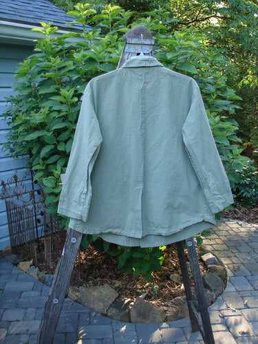 2000 Parachute Double Button Jacket Floral Eucalyptus Size 0 displayed on a wooden stand, showcasing its double-breasted design, round hem, cuffed sleeves, and metal buttons, highlighting elegant craftsmanship and vintage appeal.