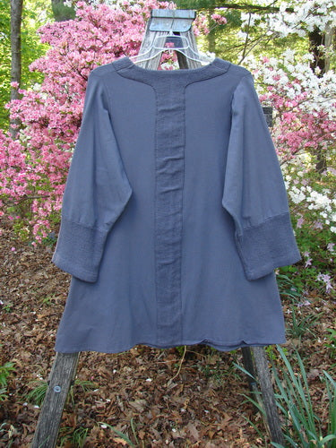 Barclay Cotton Lycra Celtic Moss Single Pocket Tunic Unpainted Grey Plum Size 1 displayed on a wooden ladder with distinctive Celtic Moss accents on the cuffs and panels, showcasing a relaxed, creative fit.