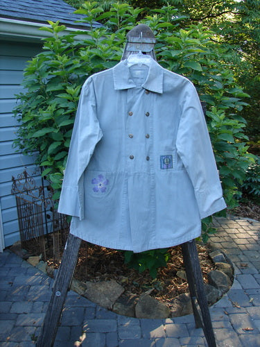 2000 Parachute Double Button Jacket Floral Robin's Egg Altered Size 0 displayed on a hanger, showcasing its double-breast line, cuffed sleeves, metal buttons, and tiny front pockets.
