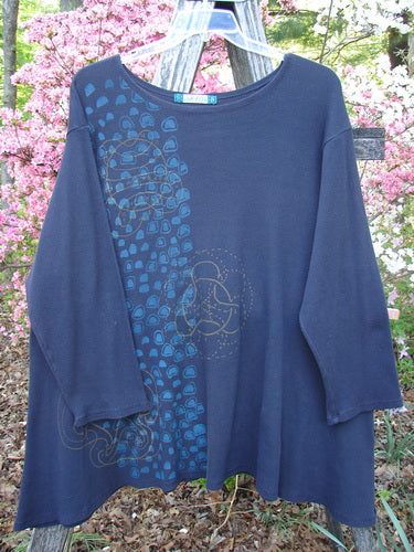Barclay Thermal A Lined Tunic Top Paisley Graph Black Size 2, featuring a scoop neckline, ¾ sleeves, teal semi-circles, and green mandala motifs, hangs elegantly on a rustic wooden ladder.