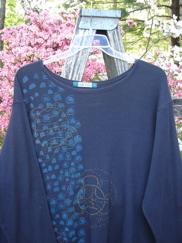 Barclay Thermal A Lined Tunic Top Paisley Graph Black Size 2 features a navy-blue pullover with abstract geometric prints in lighter blue and gold on the front, displayed on a hanger outdoors.