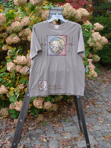 1999 Short Sleeved Tee Circle Bloom Shale Size 1 on a hanger, featuring a circle bloom theme painting on the front, slightly rolled ribbed neckline, and a medium weight organic cotton jersey fabric.