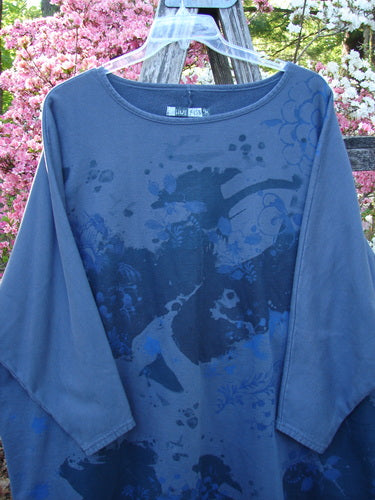 Barclay Fleece Big Square Pullover Botanical Path Night Navy OSFA hanging on a clear hanger, featuring a loose fit, dolman shoulders, and abstract print. Set against a wooden trellis backdrop with flowering shrubs.