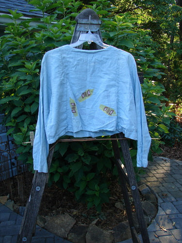 2000 Hemp Cotton Shorty Jacket Tri Rake Blue Jet Size 1 displayed on a clothes rack, featuring a rounded hem, longer sleeves, vertical curved panels with tiny loops, and shell button closure.