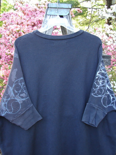 Barclay Fleece Banded Sleeve Dolman Top features a wide, boxy shape with three-quarter dolman sleeves and abstract patterns, hanging outdoors. Ideal for showcasing creative individuality from Bluefishfinder.com.