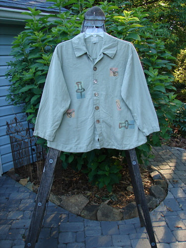 2001 P3 Top Junk Drawer Kelp Size 0 displayed on a wooden hanger, showcasing its long sleeves, rounded hemline, and six abalone shell buttons. The shirt is part of Bluefishfinder.com's vintage collection.