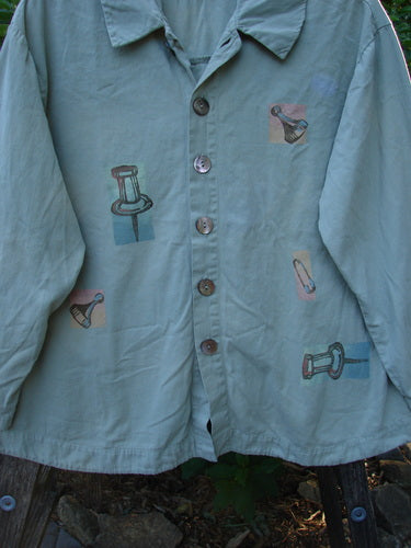 2001 P3 Top Junk Drawer Kelp Size 0: A long-sleeved shirt with pictures, featuring six abalone shell buttons, rounded hemline, tailored upper back, and signature Blue Fish 2001 stamp.