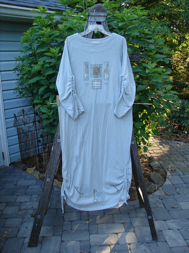 1999 Starlight Dress Celtic Garden Blue Horizon Size 0 displayed on a wooden rack, showcasing long sleeves and a unique neckline with sleeve lacings, embodying BlueFishFinder's vintage style and artistic detailing.