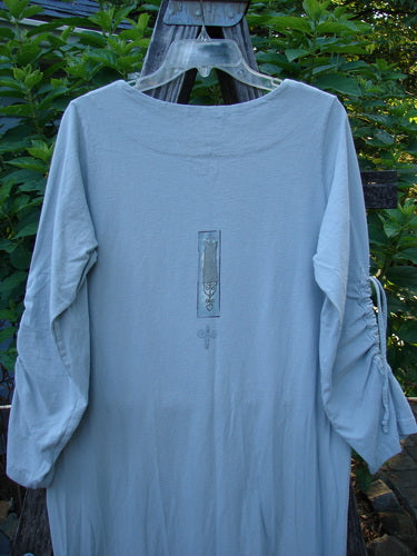 1999 Starlight Dress Celtic Garden Blue Horizon Size 0 displayed on a clothes rack, showcasing long sleeves, softer rolled double layered neckline, sleeve lacings, and vertical drawcord accents.