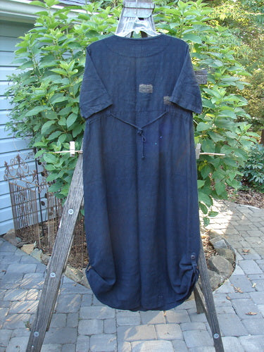 1999 Textured Linen Water Dress Goldfish Raven Size 0, displayed on a clothes rack, featuring a unique basket weave texture, empire waistline, full sweeping skirt, rounded neckline, and pleated front.