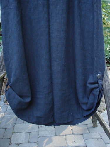 1999 Textured Linen Water Dress Goldfish Raven Size 0 displayed on a wooden stand, showcasing its empire waistline, full sweeping skirt, pleated front, and buttoned hem sides.