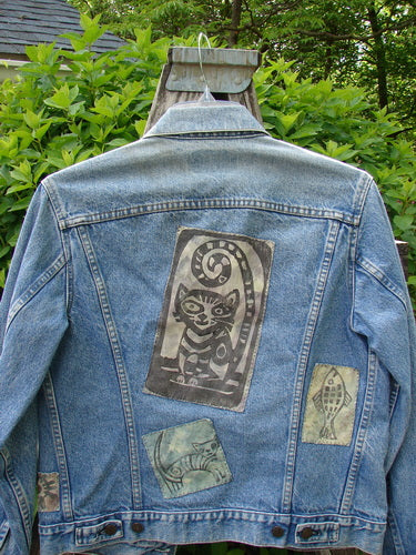 1995 Patched Levi Strauss & Co Denim Blue Jean Jacket features appliquéd animal patches, including a central striped cat, on its back. The jacket showcases vintage-style details and a unique artistic theme.