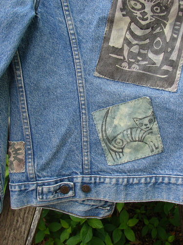1995 Patched Levi Strauss & Co Denim Blue Jean Jacket, Size 0, featuring varied cat motif patches on the lower back, showcasing unique hand-painted designs against vintage denim, embodying creative individuality.
