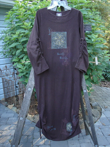 1999 Starlight Dress Celtic Key Deep Burgundy Size 0 displayed on a wooden ladder, showcasing a long, straight shape with sleeve lacings and a double-layered neckline.
