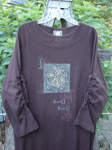 1999 Starlight Dress Celtic Key Deep Burgundy Size 0 displayed on a hanger outdoors, showcasing its long sleeves, rolled double-layered neckline, and intricate sleeve lacings.