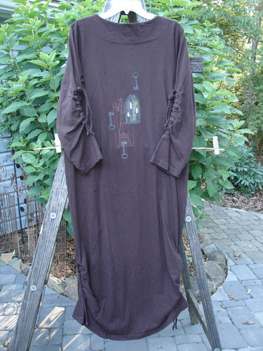 1999 Starlight Dress Celtic Key Deep Burgundy Size 0, featuring a softer rolled double layered neckline, lovely sleeve lacings, and a straighter longer shape, displayed hanging on a ladder.